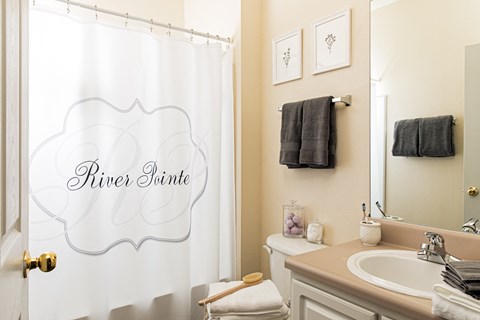 a small bathroom with a white shower curtain