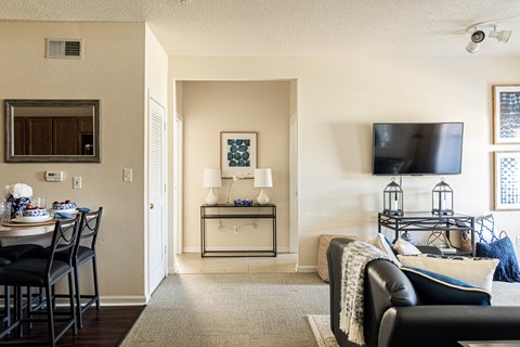 a living room with a tv and a table with chairs