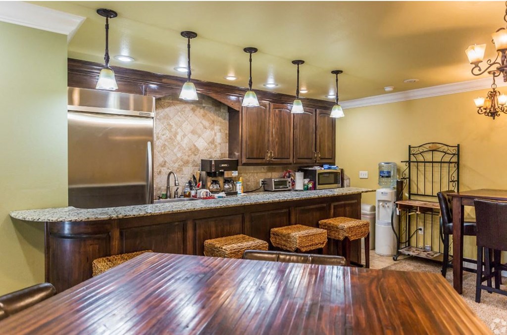 a kitchen and dining area with a wooden table and stools