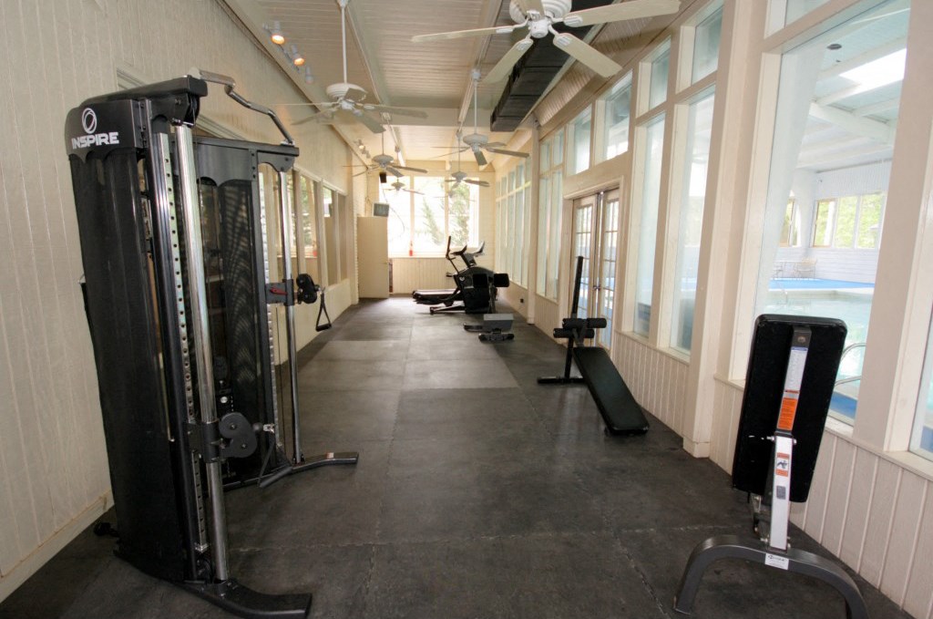 a gym with weights and cardio equipment in a building with windows