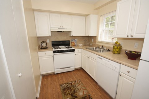 a kitchen with white cabinets and a stove and a sink