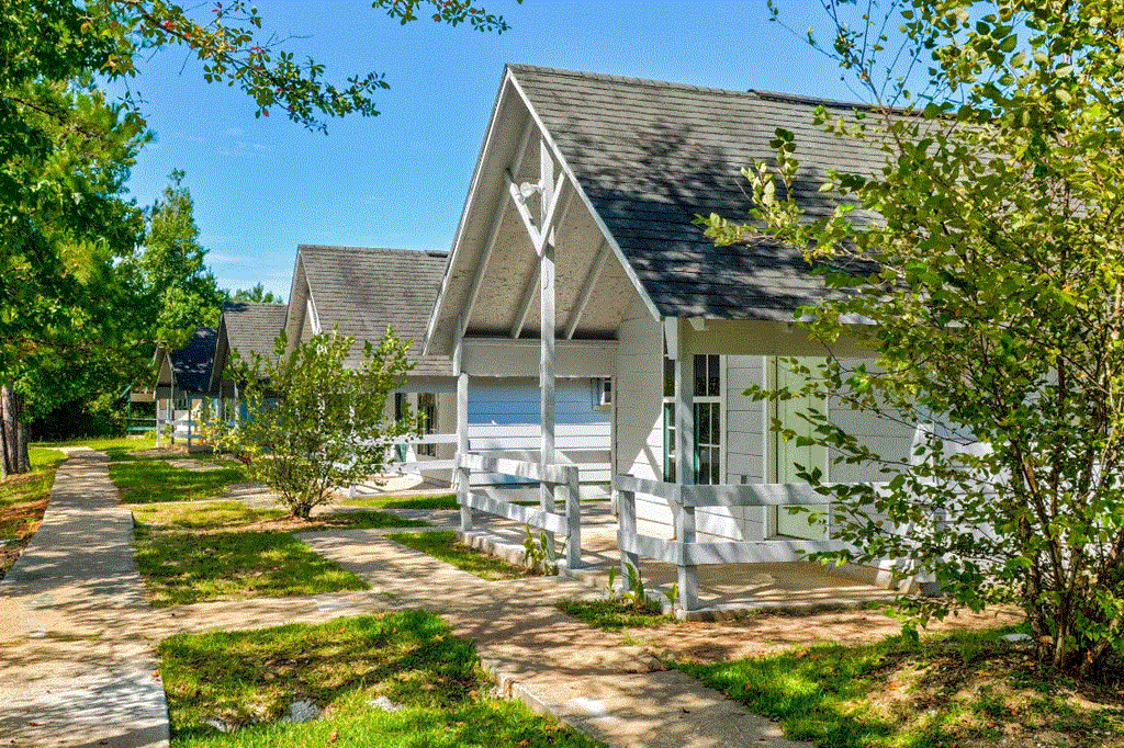 a row of white cottages on a sunny day