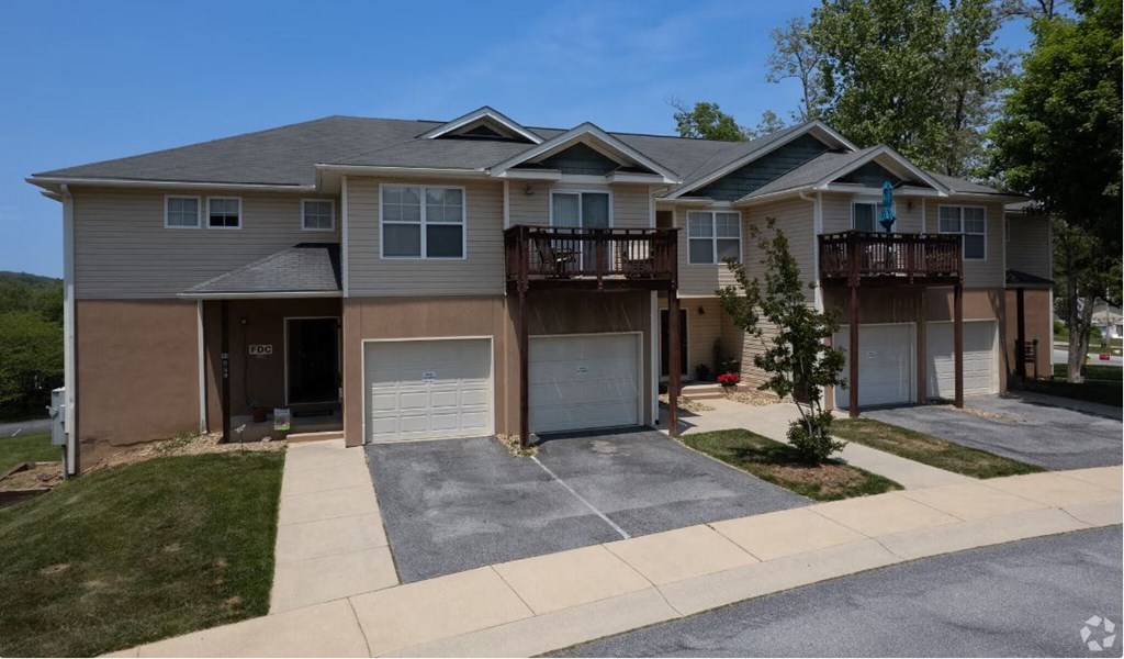 a two story house with a garage and two balconies