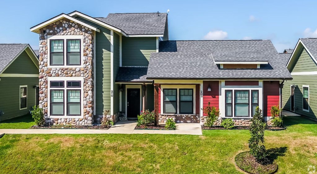 a house with green and red siding and a gray roof