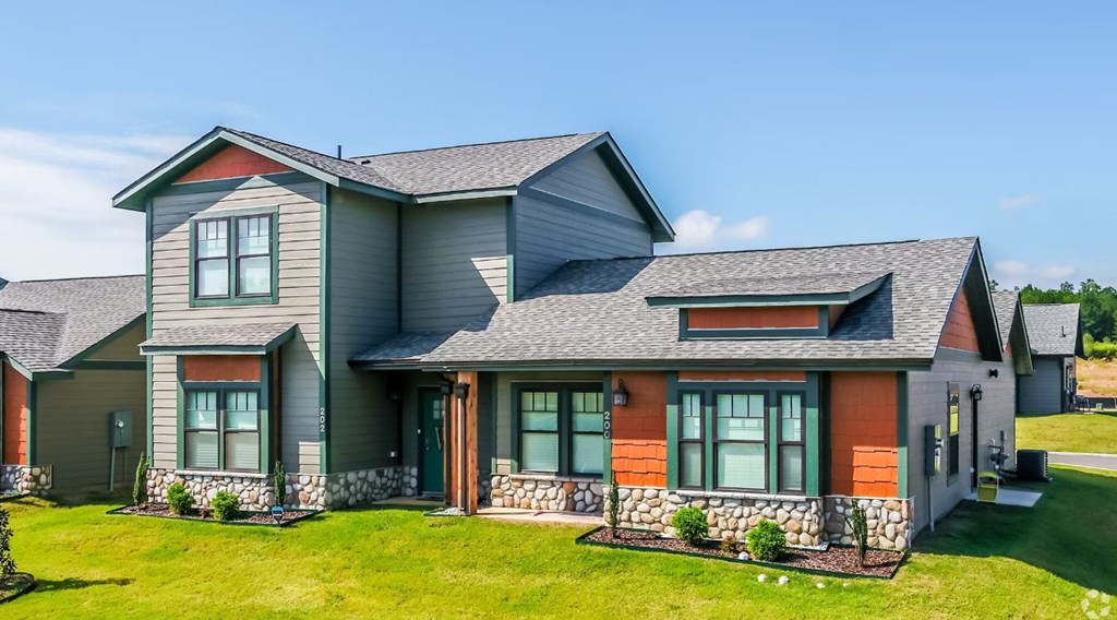 a house with a gray roof and a green lawn