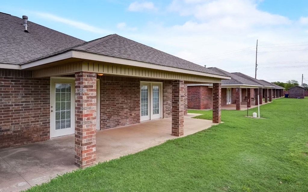 a row of brick buildings with a grassy area in front of them
