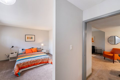 A bedroom with a bed and a chair in it.
