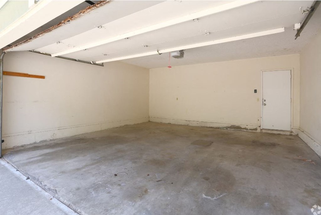 an empty garage with white walls and a white door