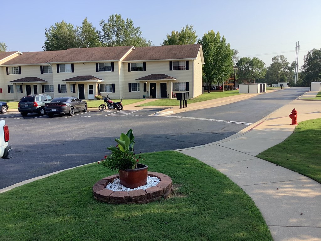 this is a picture of a street in front of a two story apartment building