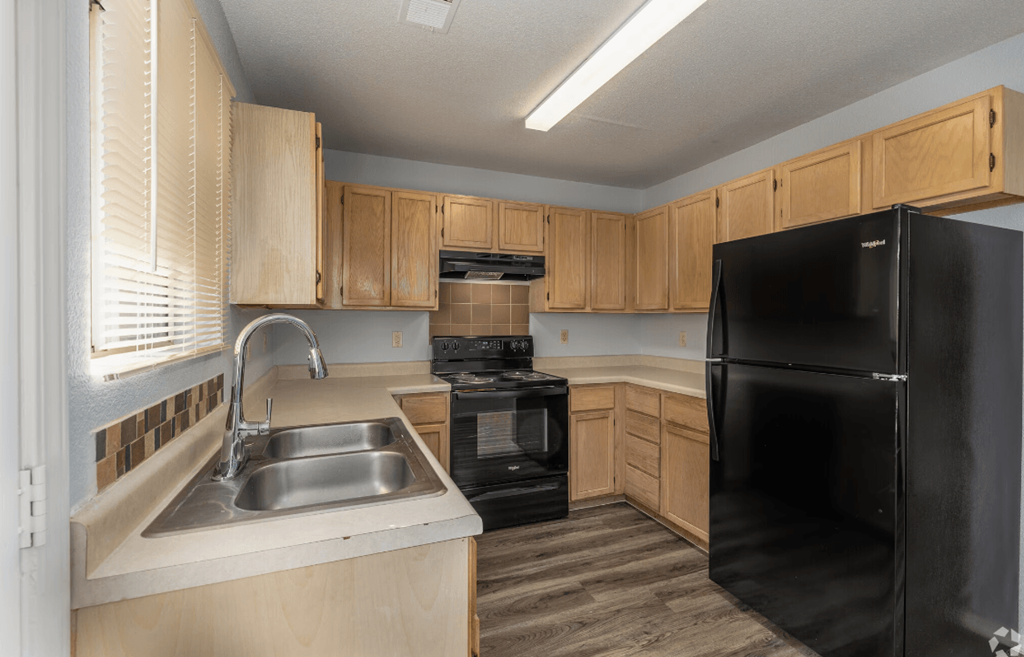 a kitchen with black appliances and wooden cabinets