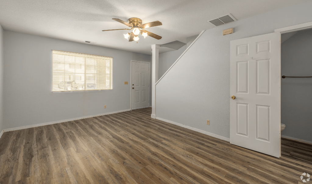 an empty bedroom with a ceiling fan and a closet