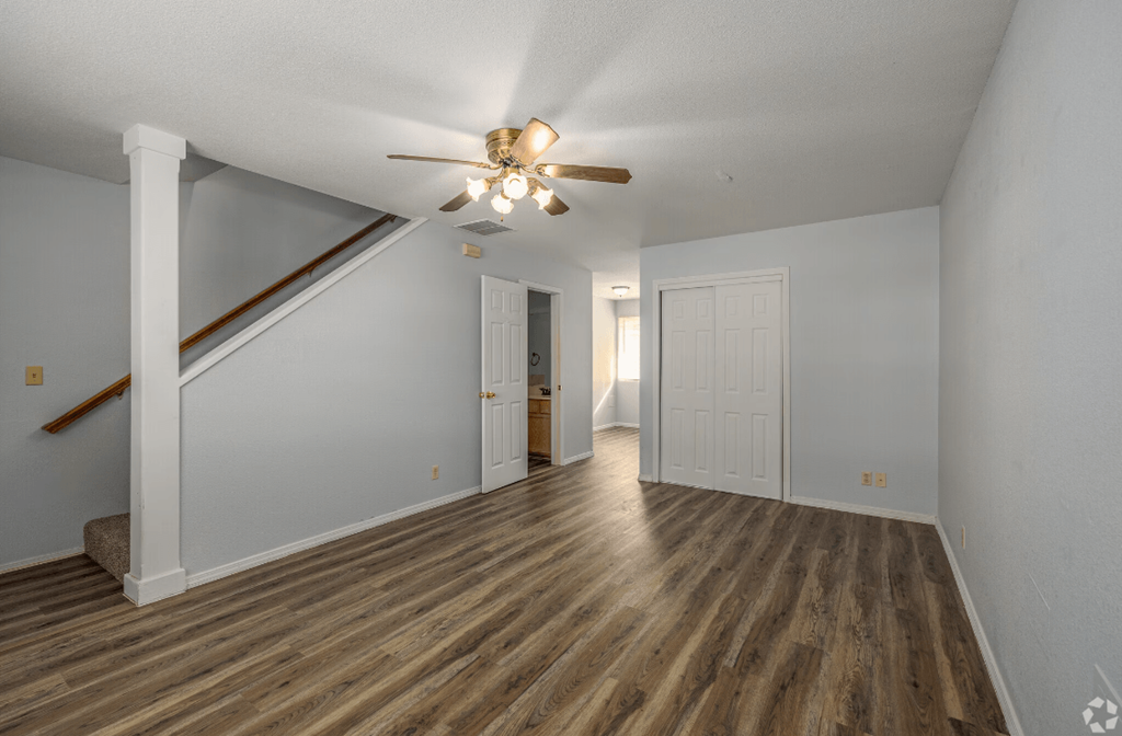 a living room with hardwood floors and a ceiling fan