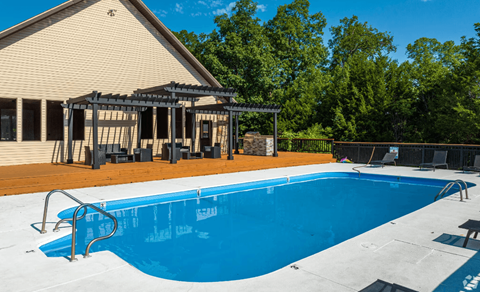 a swimming pool with a pergola next to a house