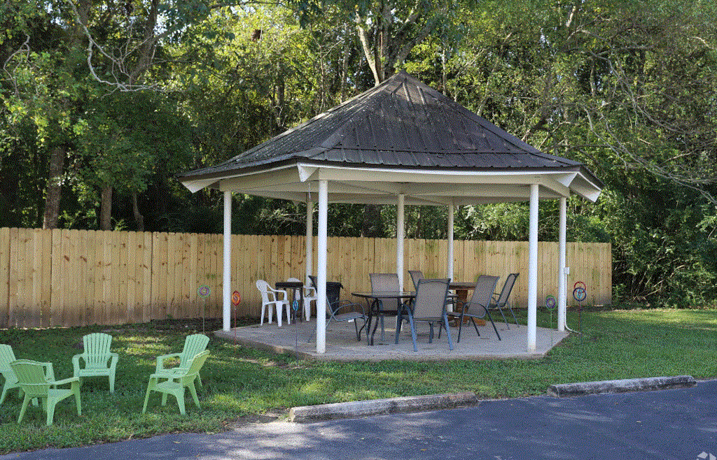 a gazebo with a table and chairs in a yard