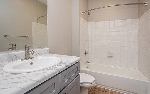 A bathroom with a white sink and a white toilet.