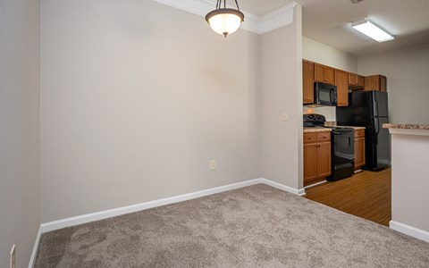 A kitchen area with a black refrigerator and microwave.