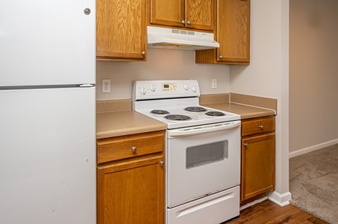 A white stove and oven in a kitchen with wooden cabinets.