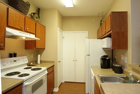 A kitchen with a white stove top oven and a white refrigerator.