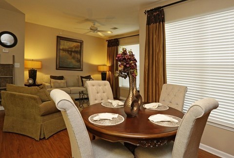 A dining room with a brown table and chairs.