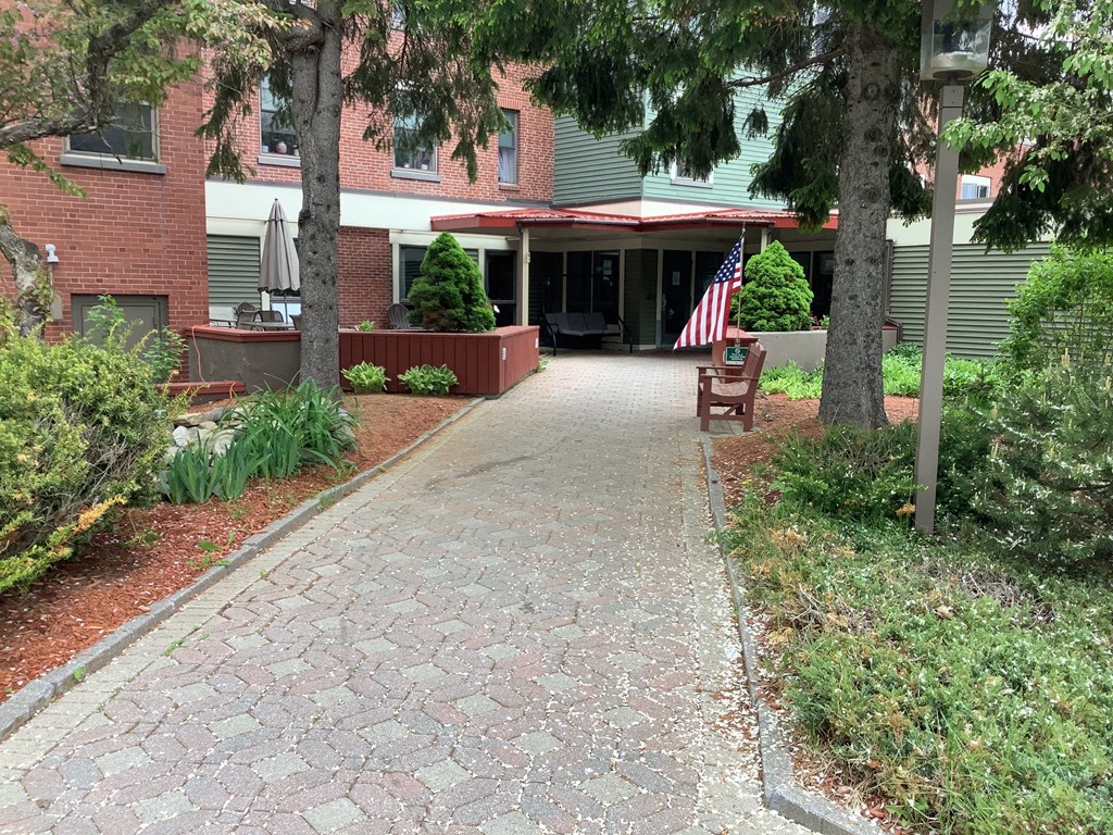 a walkway in front of a building with an flag