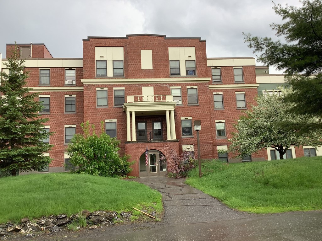 a large brick building with a sidewalk in front of it