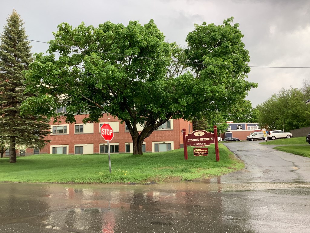 a building with a stop sign in front of a tree