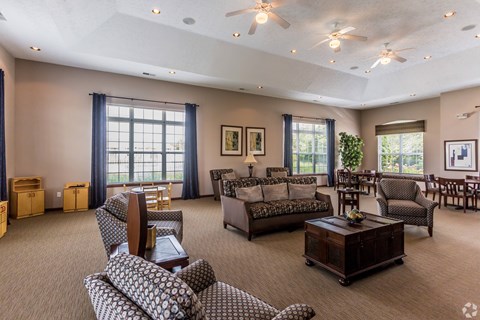 A spacious living room with a variety of seating options and a large window.