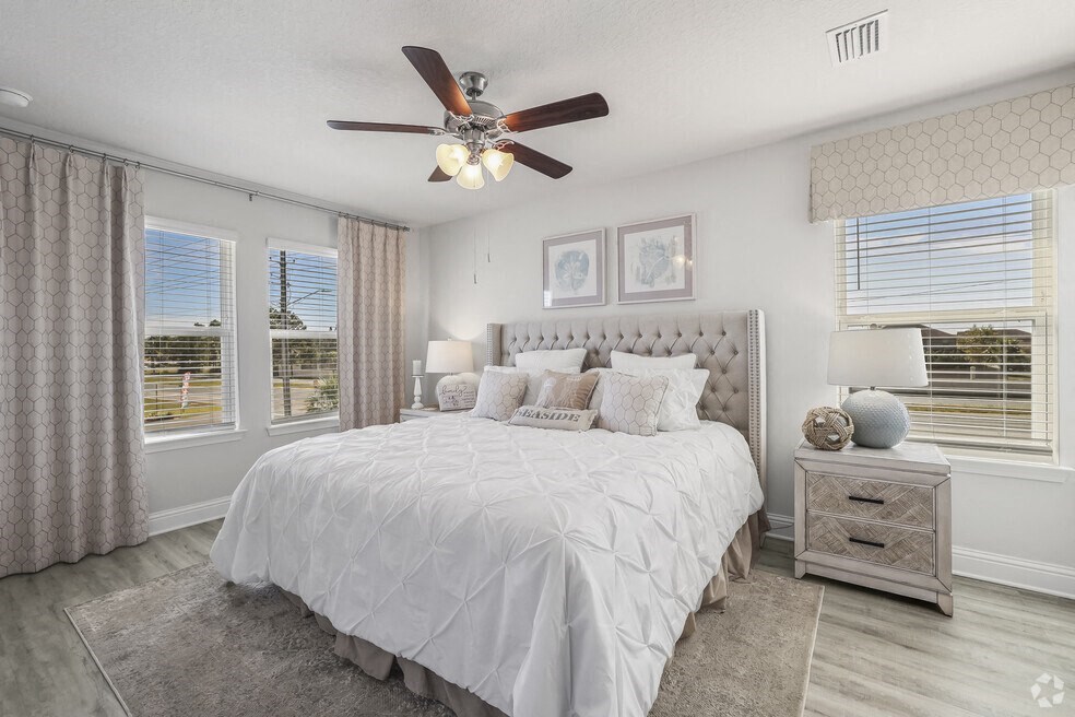 a bedroom with a large bed and a ceiling fan