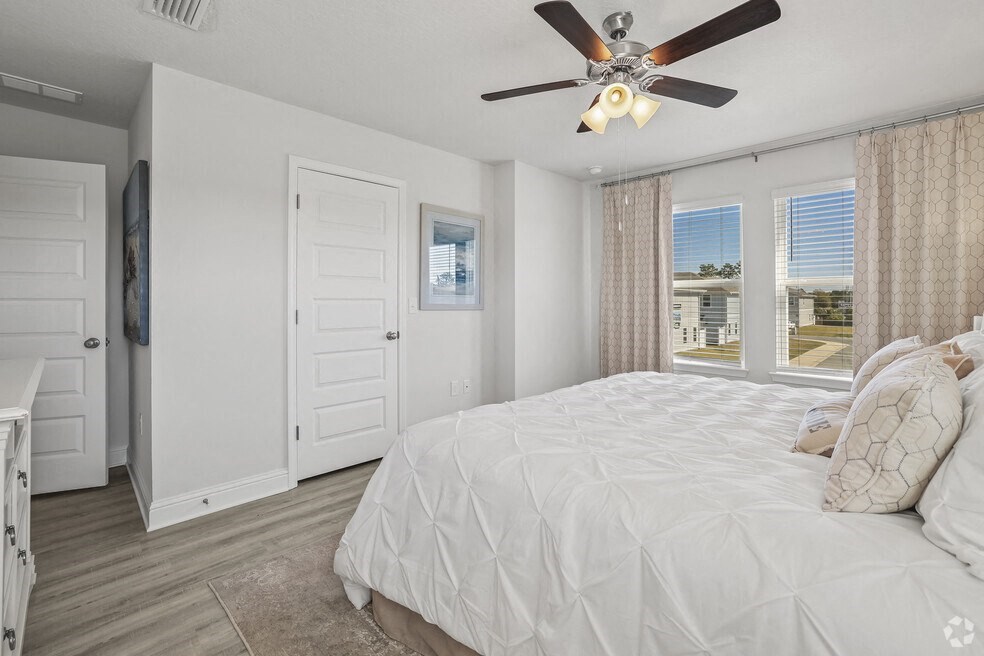 a bedroom with a large bed and a ceiling fan
