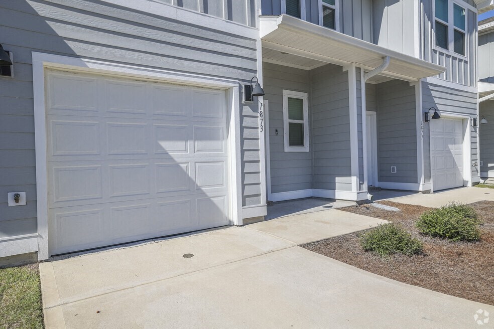 a white garage door in front of a blue house