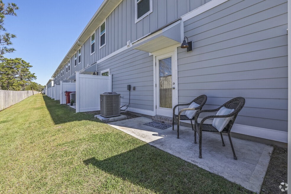 a patio with two chairs in front of a house