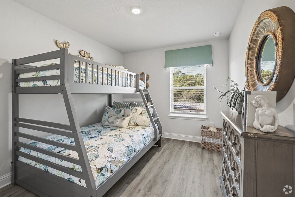 a bunk bed in a bedroom with a dresser and a window
