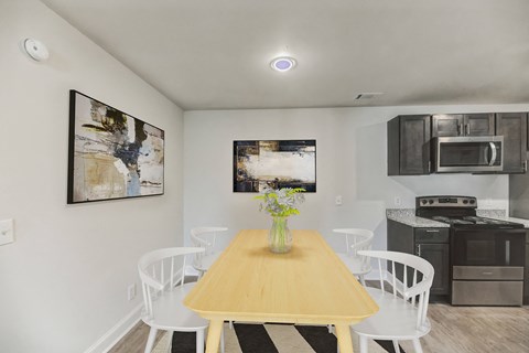 A dining room with a wooden table and white chairs.