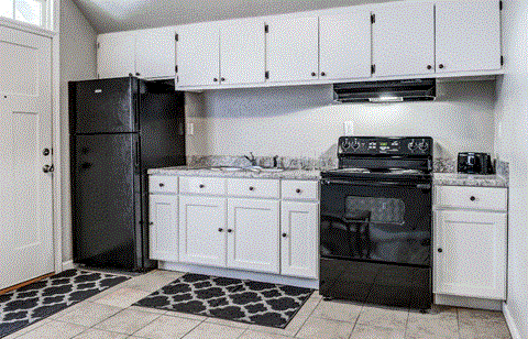 a kitchen with white cabinets and black appliances and a black refrigerator