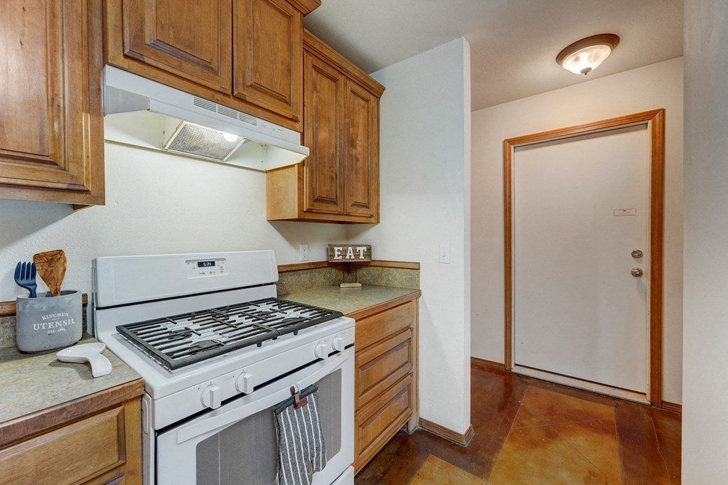 a kitchen with a white stove top oven next to a refrigerator