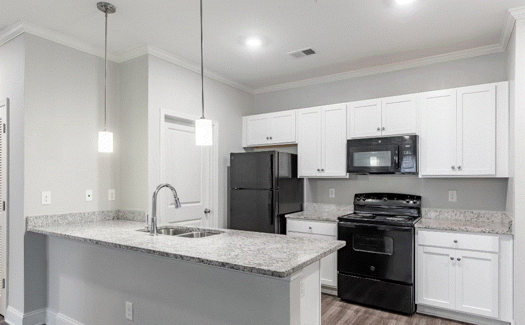 a kitchen with white cabinets and black appliances
