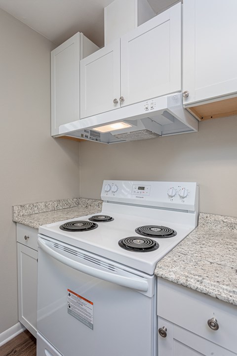 a kitchen with white appliances and white cabinets and granite counter tops