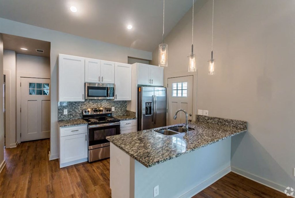 a kitchen with white cabinets and a granite counter top