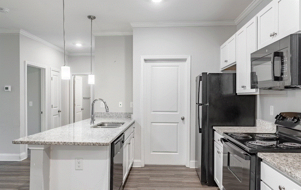 a kitchen with white cabinets and black appliances