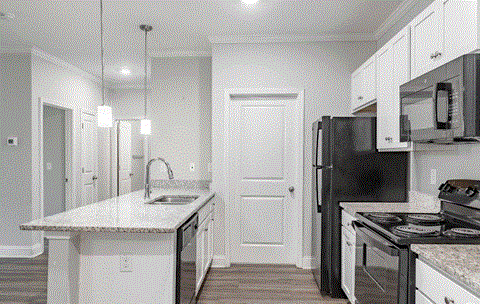a kitchen with white cabinets and a black refrigerator