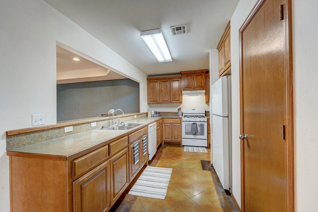 a kitchen with wooden cabinets and white appliances