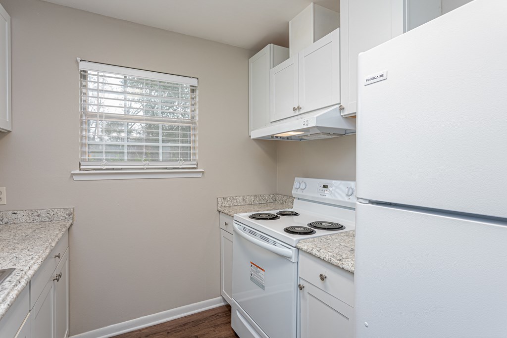 a kitchen with white appliances and granite counter tops