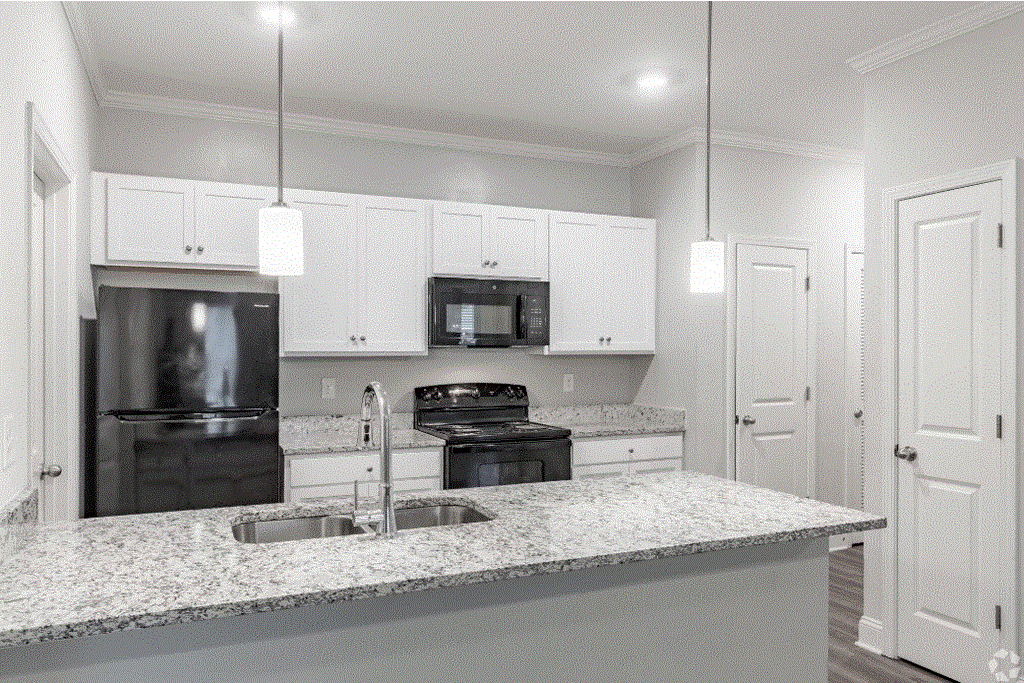 a kitchen with white cabinets and a granite counter top