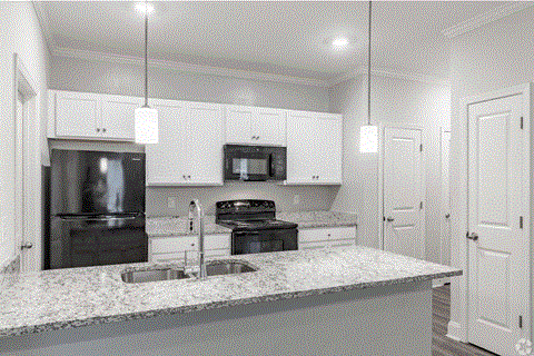 a kitchen with white cabinets and a granite counter top