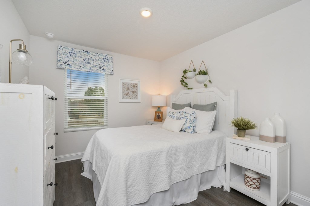 a white bedroom with a bed and a white dresser