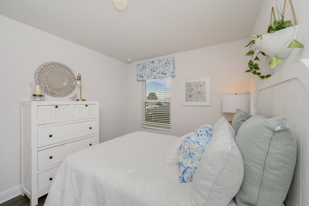 a white bedroom with a white bed and a white dresser