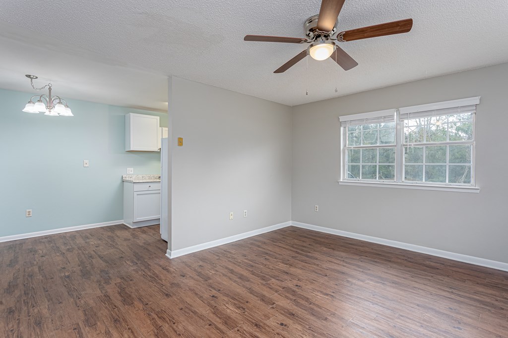 an empty bedroom with a ceiling fan