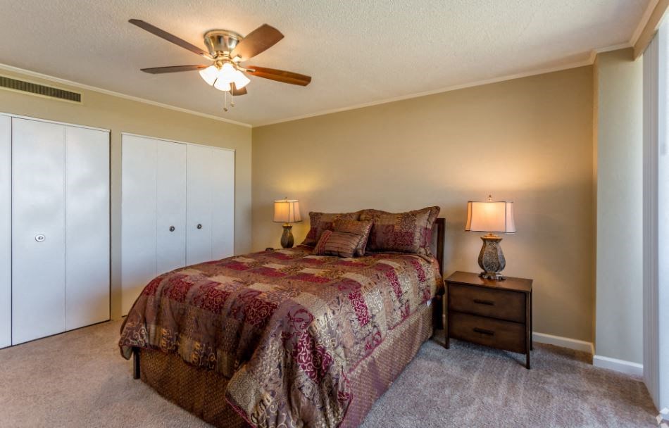 a bedroom with a bed and a ceiling fan