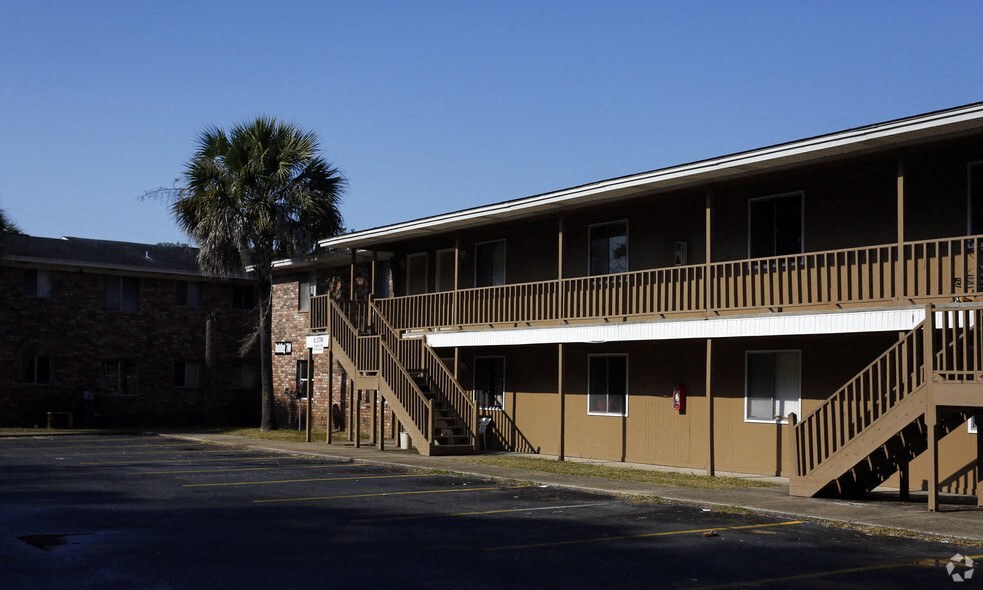 an apartment building with stairs and a palm tree