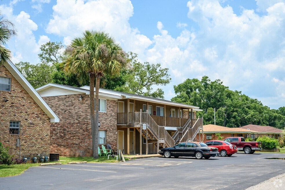a building with a palm tree and cars parked in front of it
